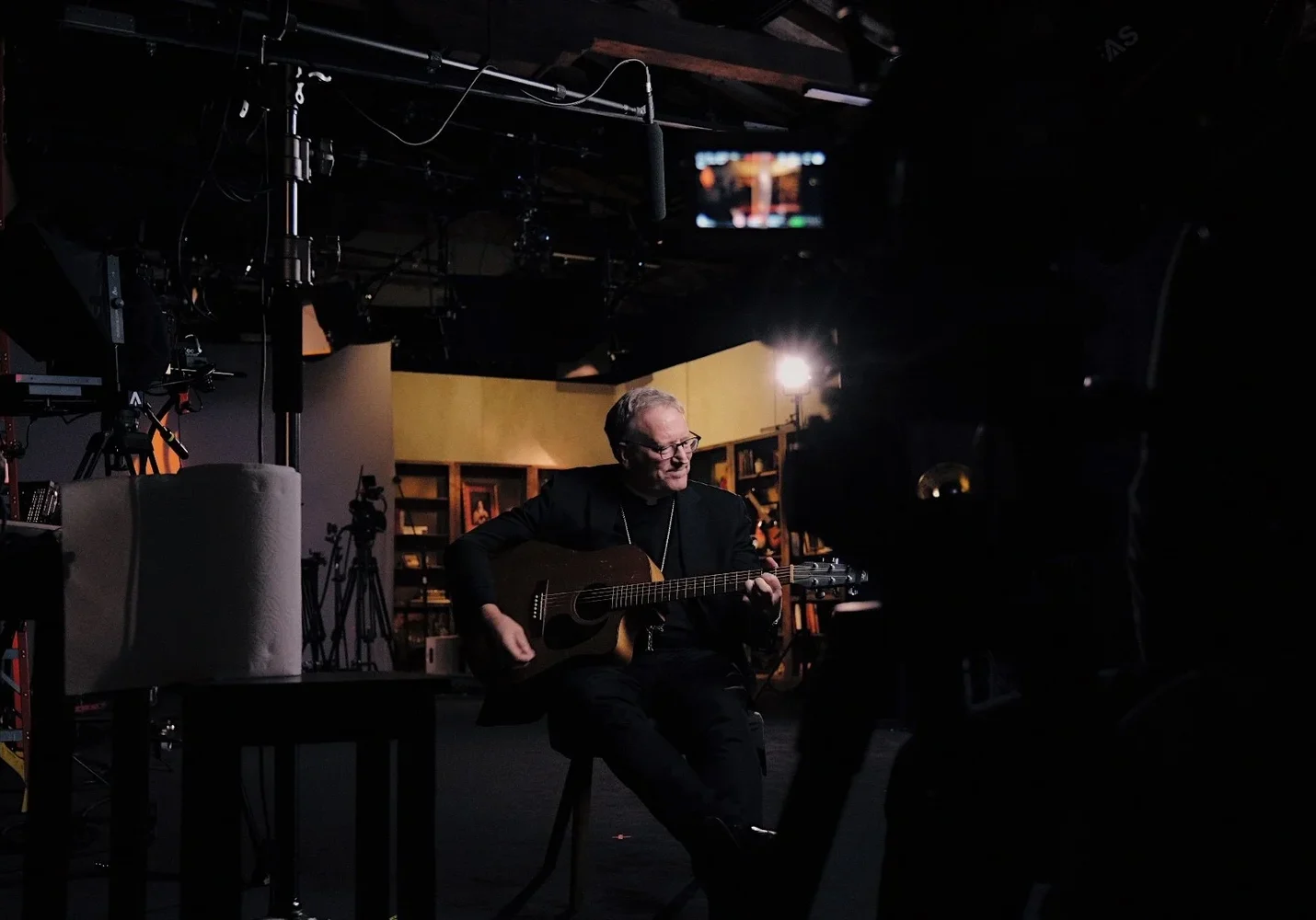 Bishop Barron playing guitar on Meaning of Music film series